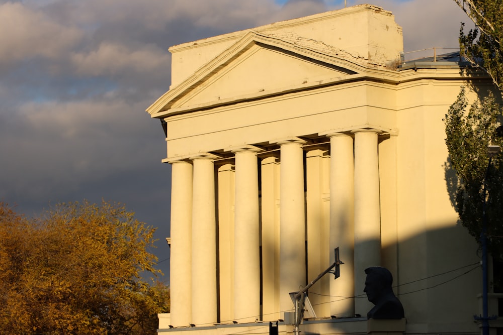 a tall white building with columns and a clock tower