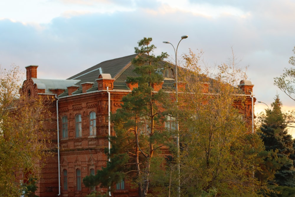 a large brick building surrounded by trees on a cloudy day