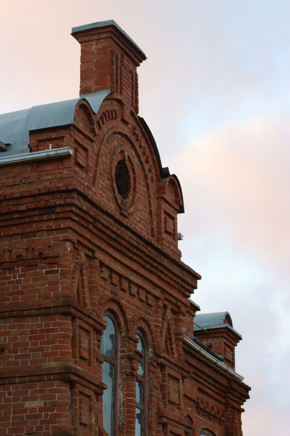 a tall brick building with a clock on it's side