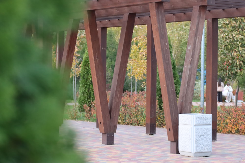 a white box sitting under a wooden structure