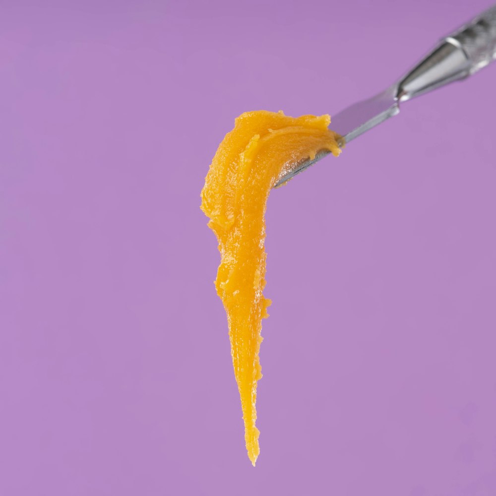 una cuchara con una cuchara llena de glaseado de naranja