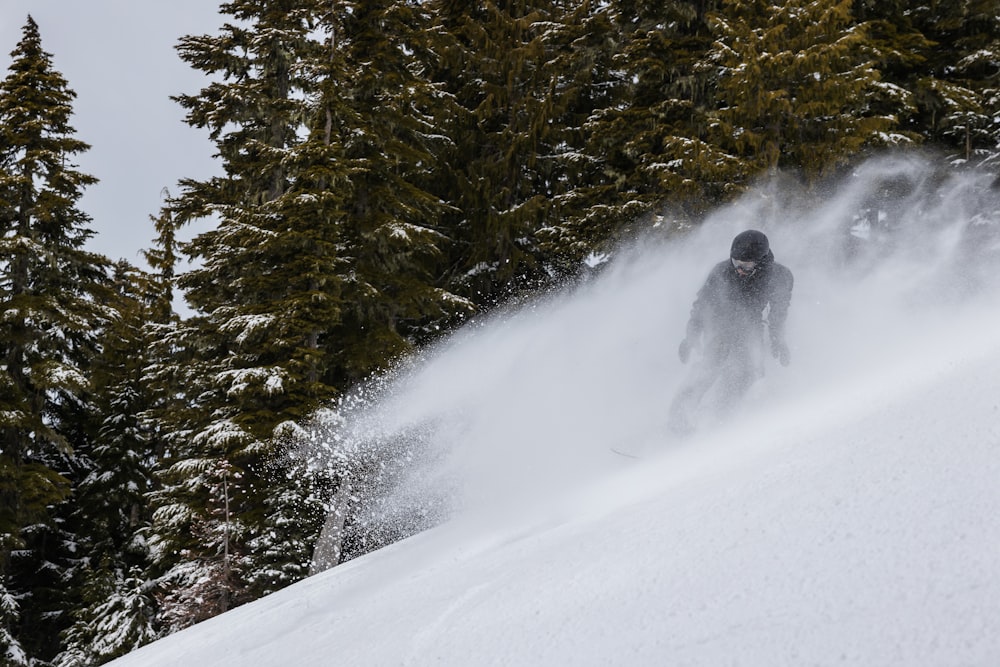 a man riding a snowboard down a snow covered slope