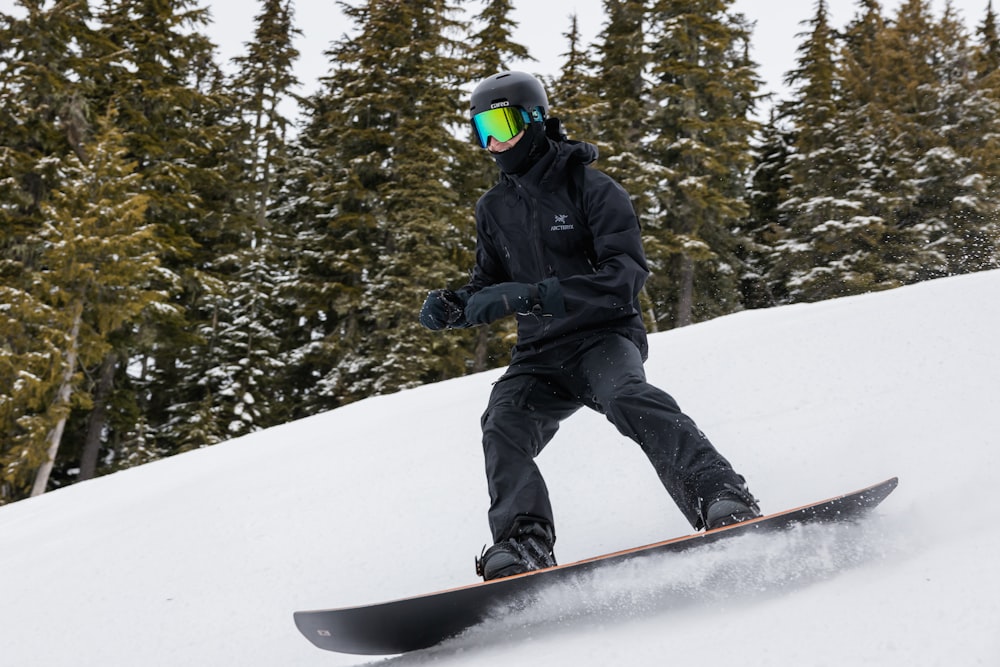 ein Mann, der mit einem Snowboard einen schneebedeckten Hang hinunterfährt