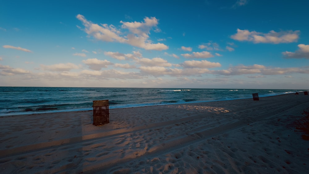 a bench sitting on the beach next to the ocean