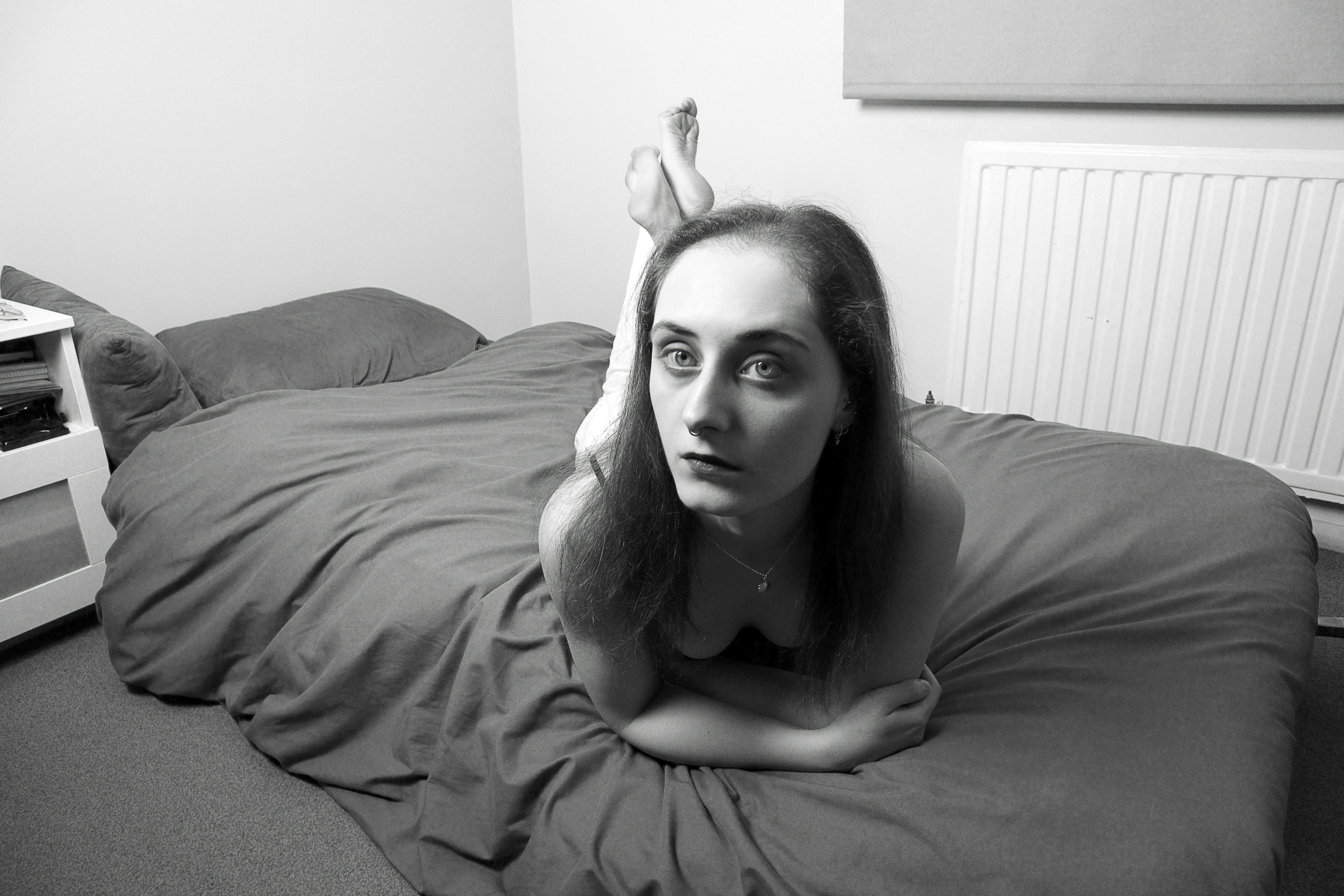 a black and white photo of a woman laying on a bed