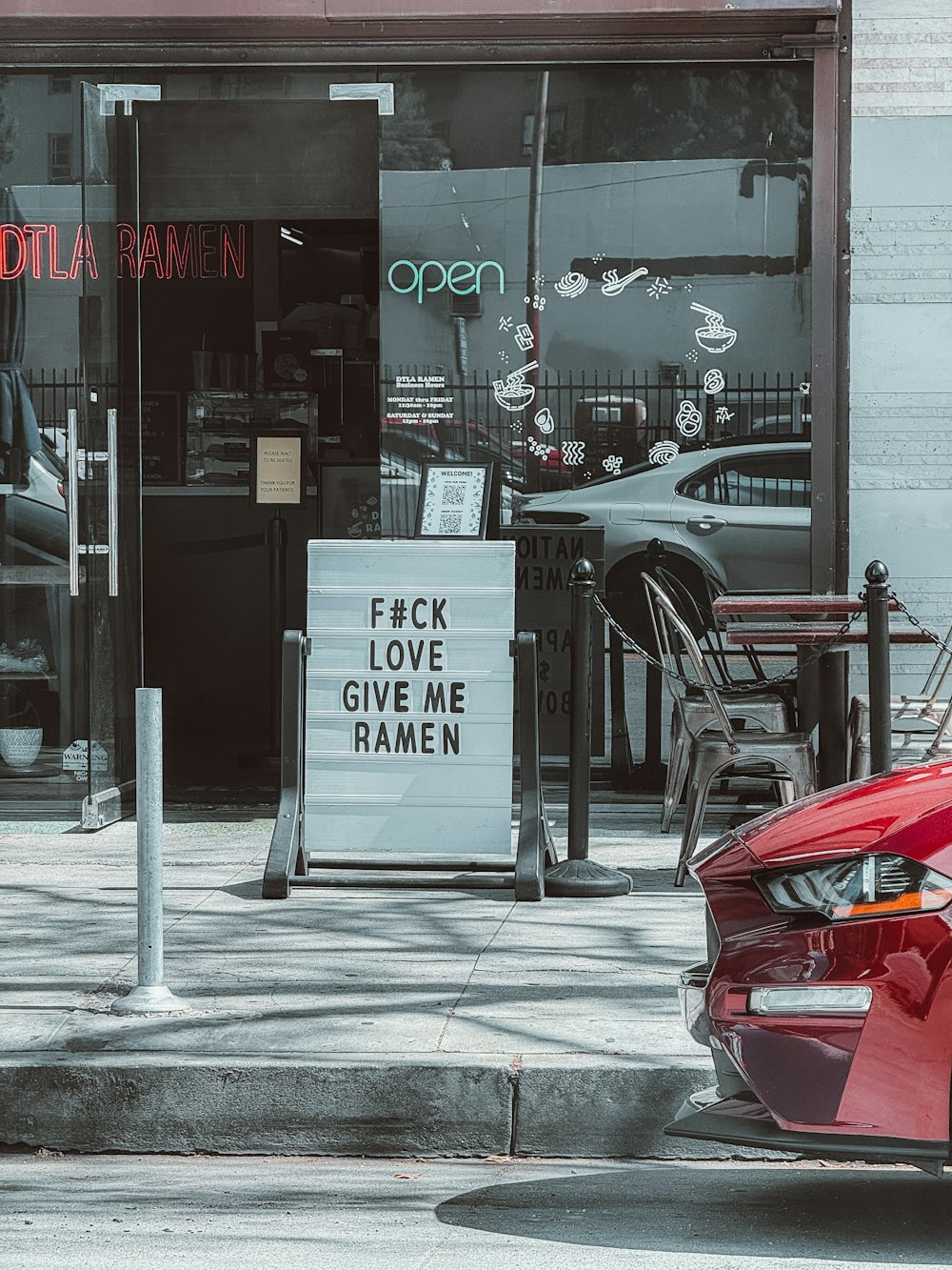 a red car parked in front of a restaurant