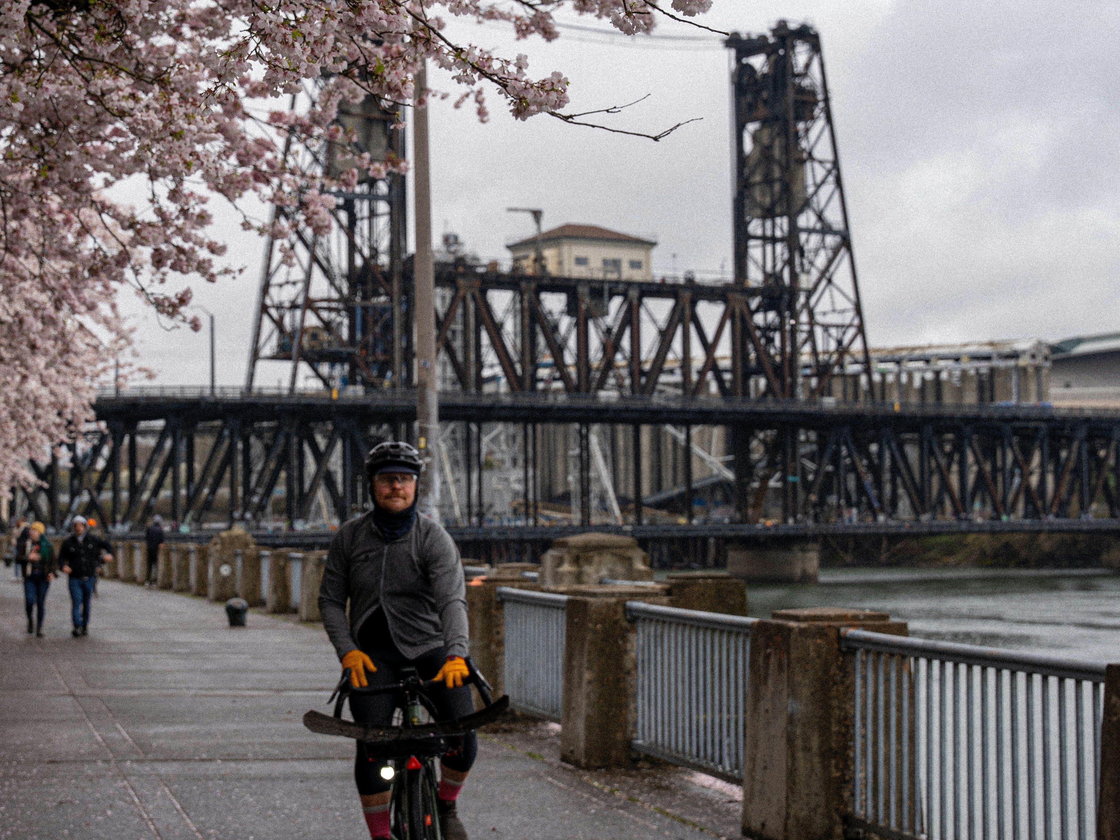 a man riding a bike down a street next to a river