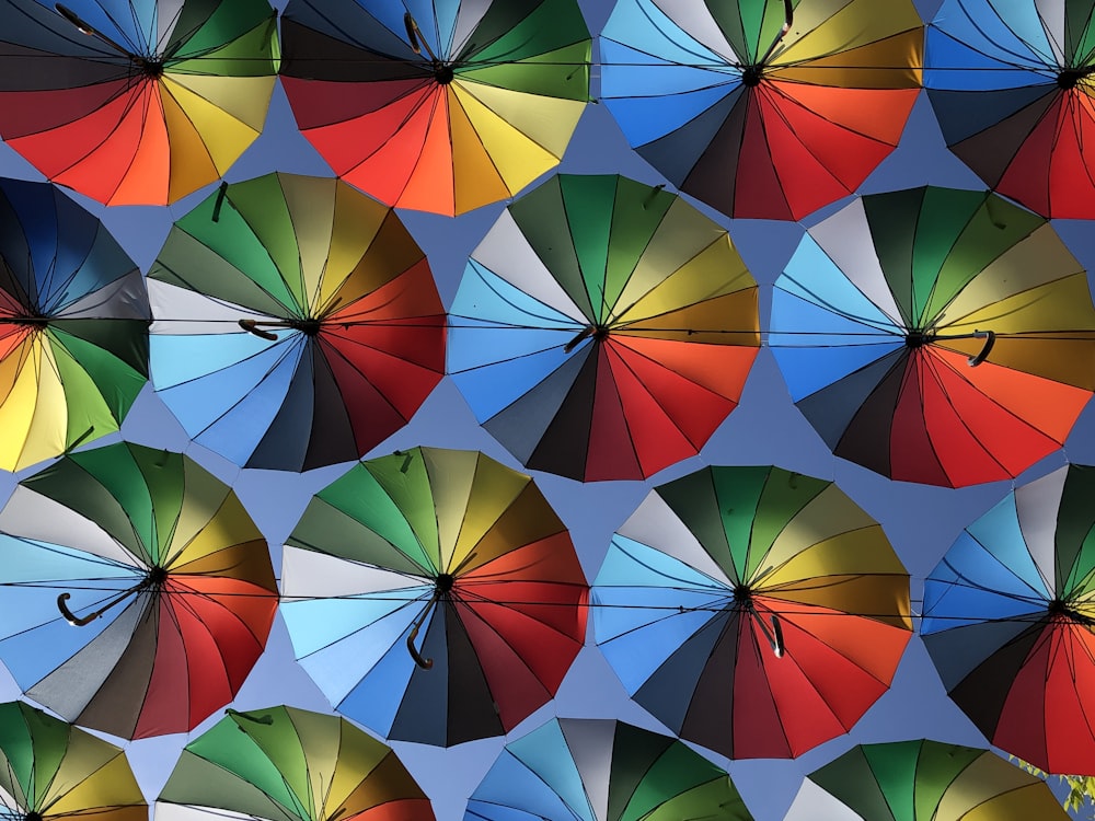 a large group of multicolored umbrellas in a blue sky