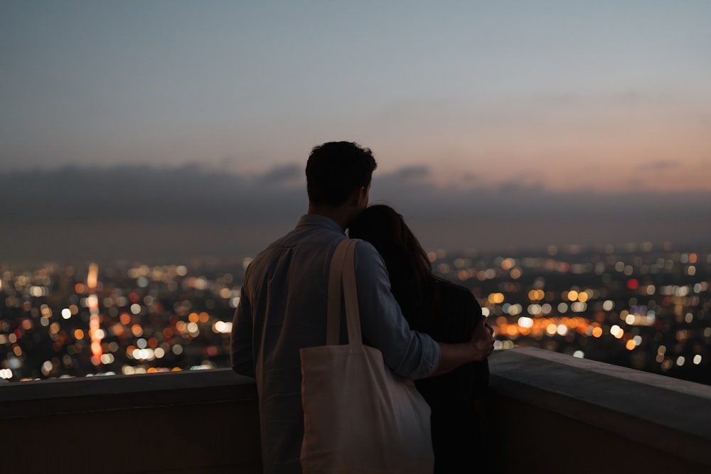 a man and a woman standing on top of a building