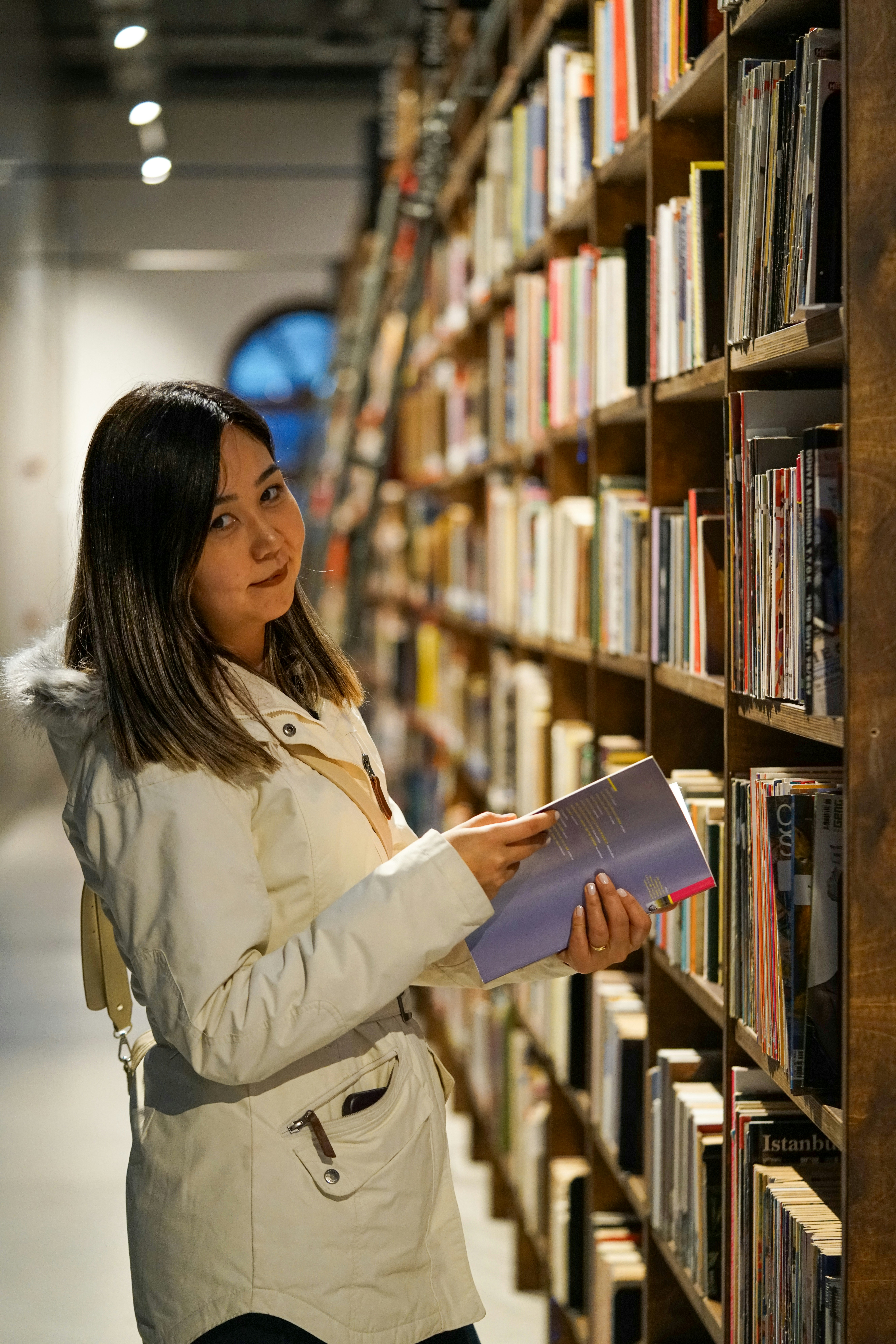 a woman looking at a book in a library