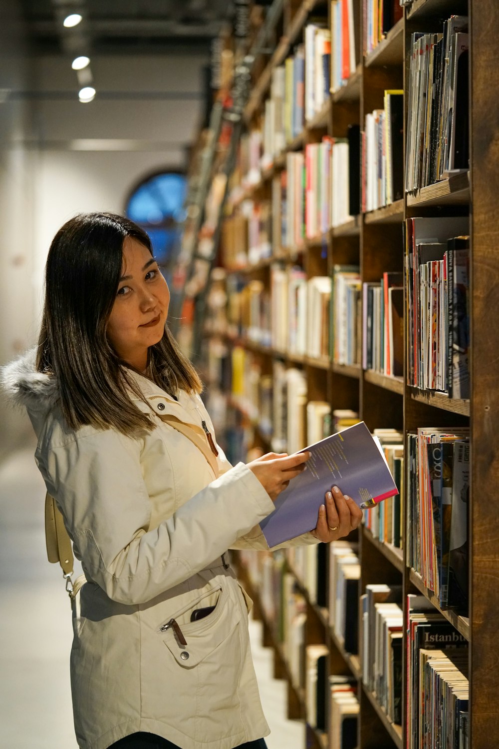 a woman looking at a book in a library