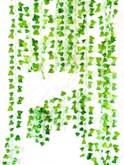 a bunch of green leaves hanging from a ceiling