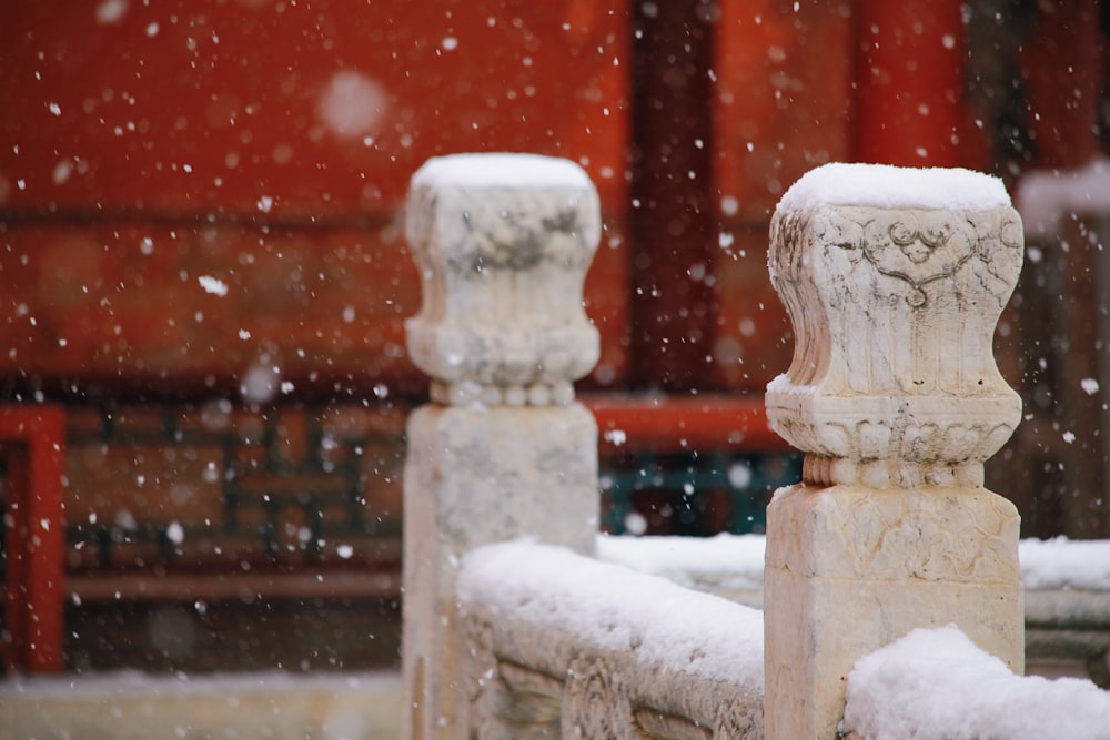 a couple of stone pillars covered in snow