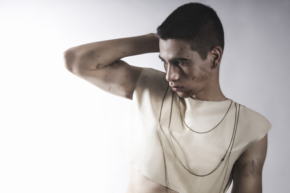 a man in a white shirt with a necklace on his neck