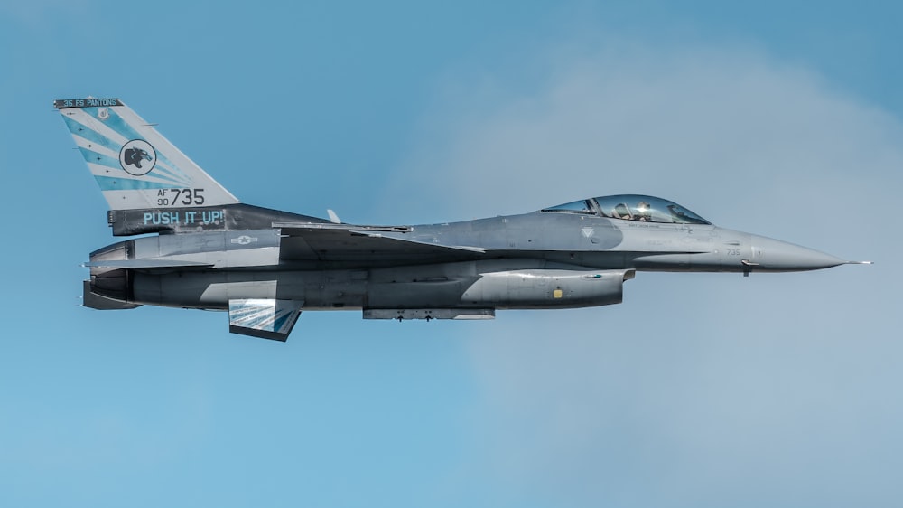 a fighter jet flying through a blue sky