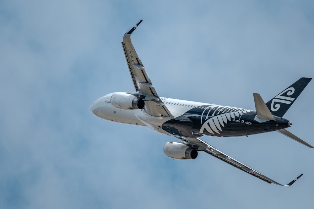 a large jetliner flying through a cloudy blue sky