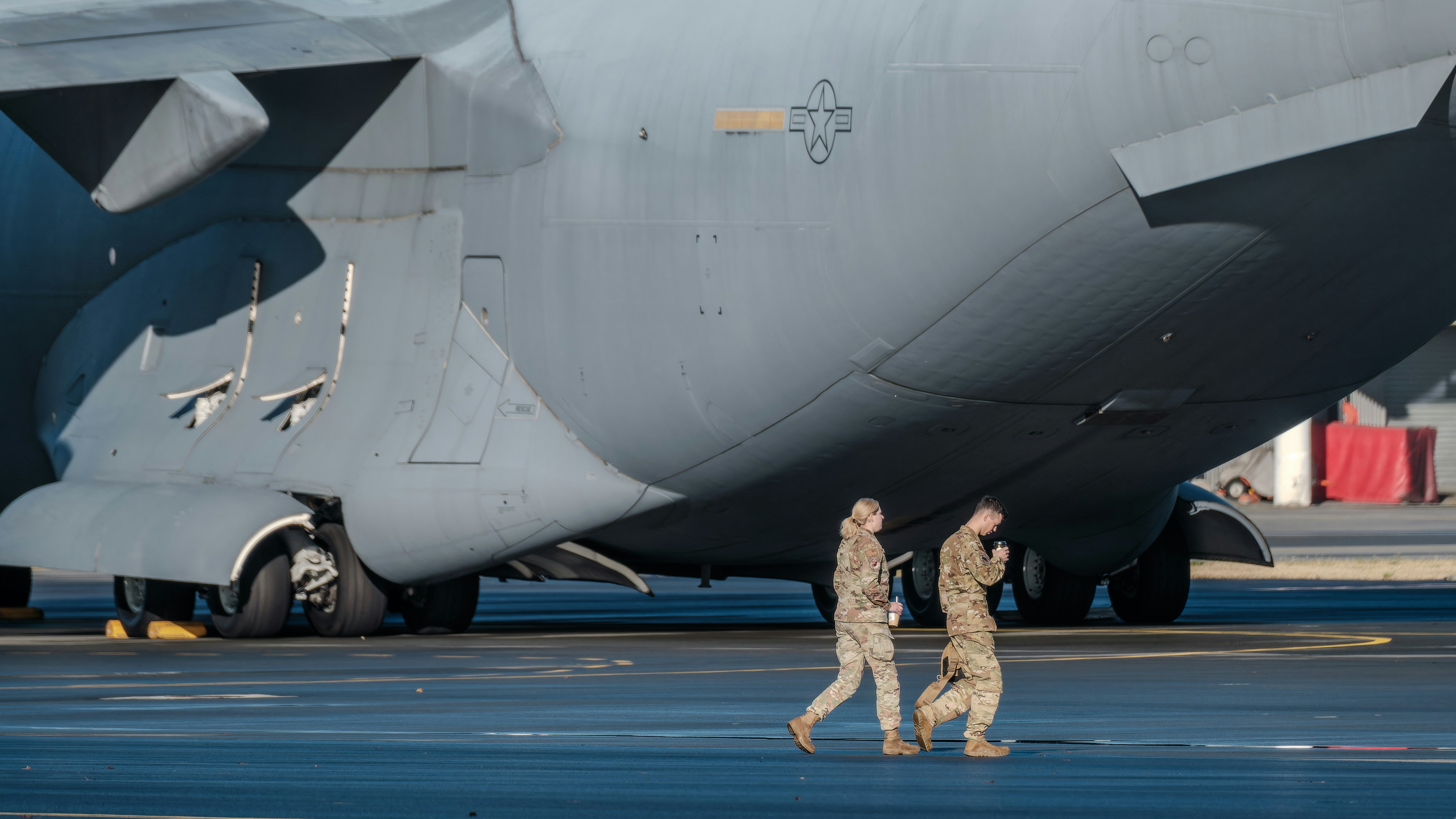 a couple of men walking next to a large airplane