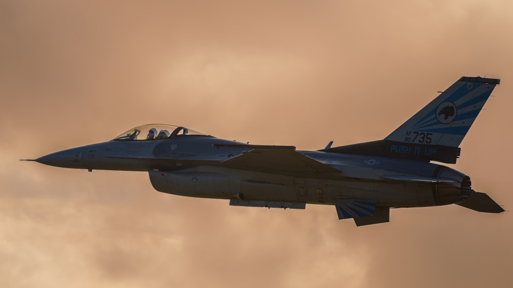 a fighter jet flying through a cloudy sky