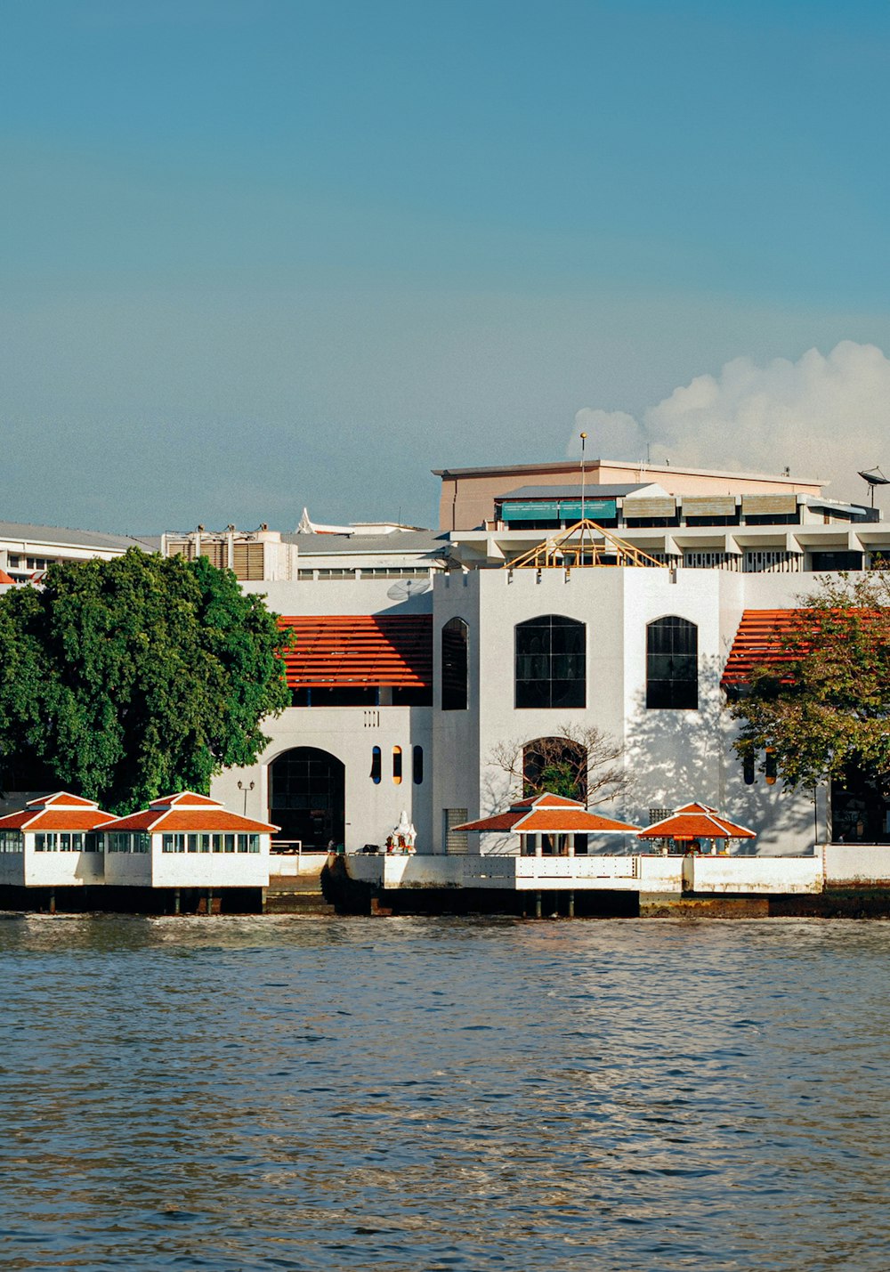 a large white building sitting on the side of a river