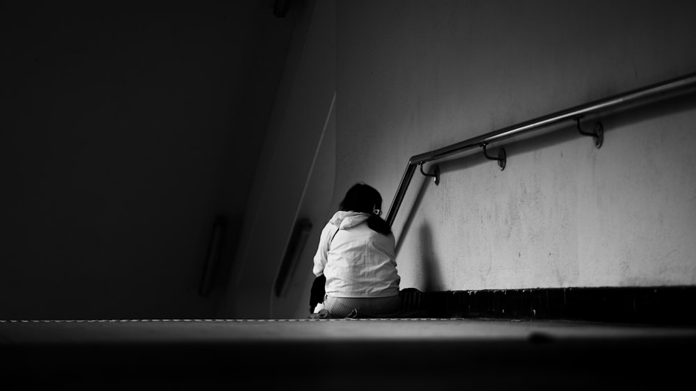 a black and white photo of a person sitting on the ground