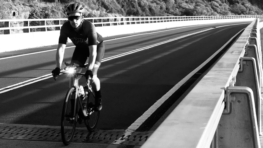 a man riding a bike across a bridge