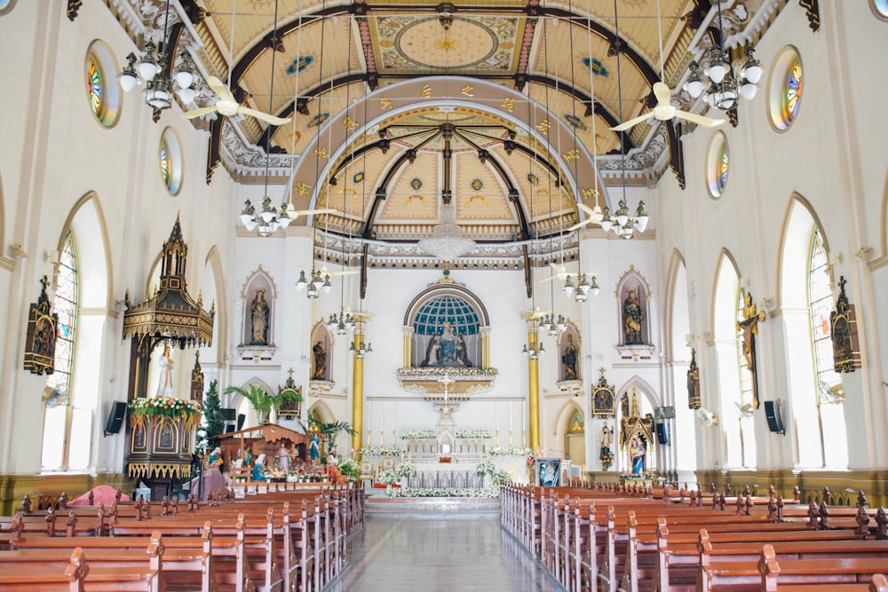 the inside of a church with pews and stained glass windows