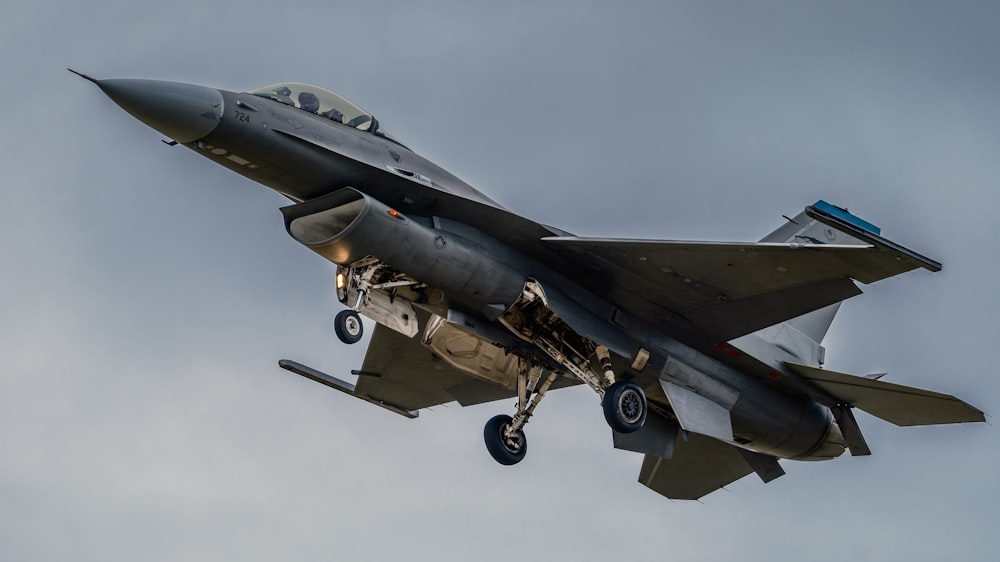 a fighter jet flying through a cloudy sky