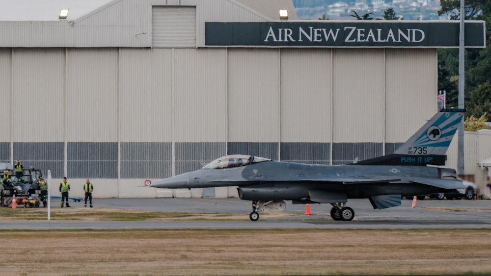 a fighter jet sitting on top of an airport tarmac