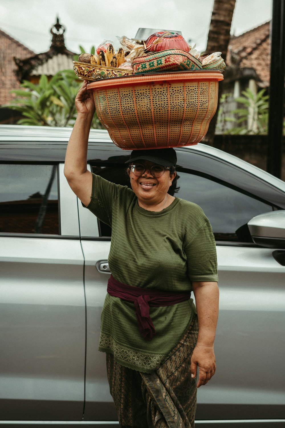 a woman carrying a basket on top of her head