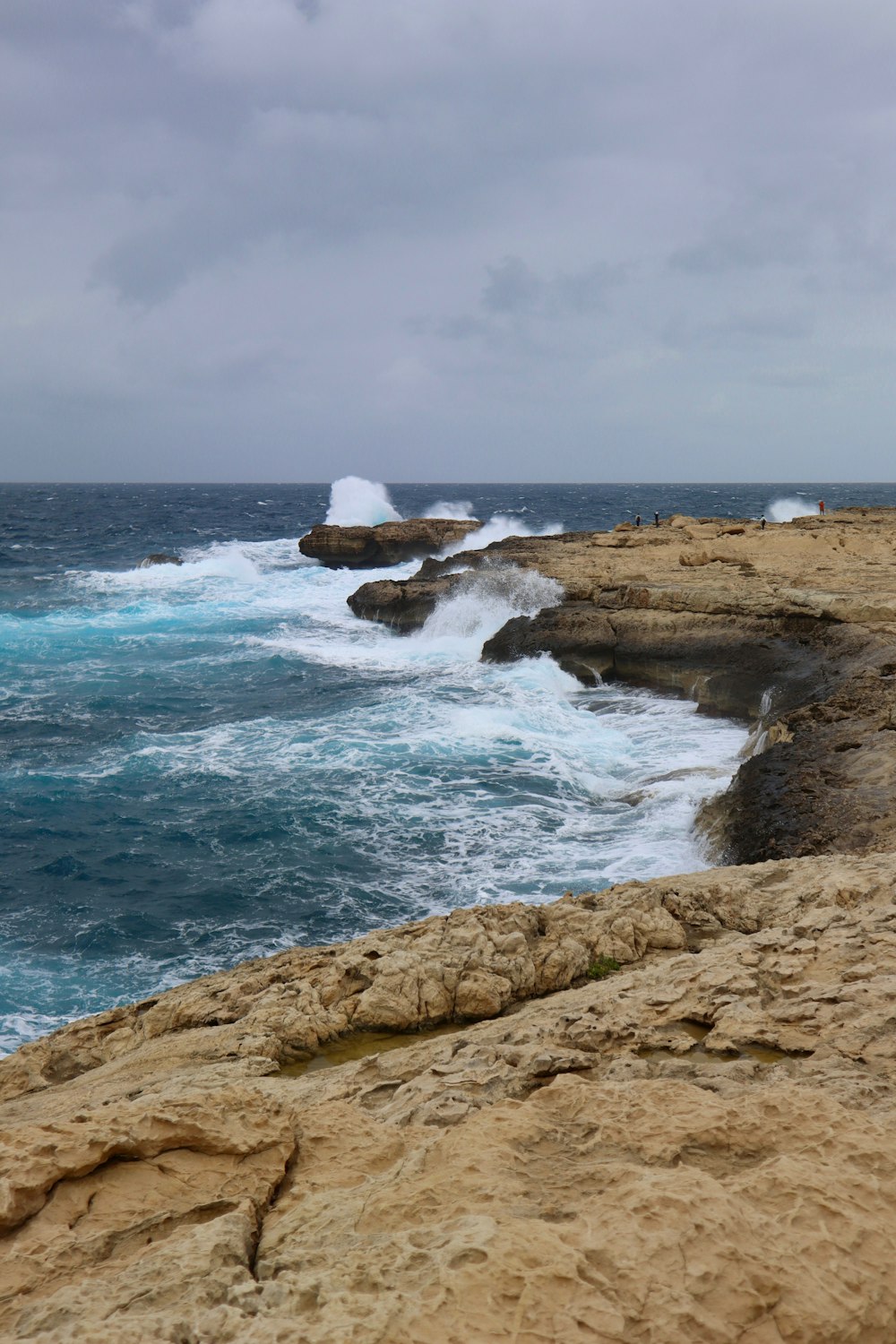 a large body of water sitting next to a rocky shore