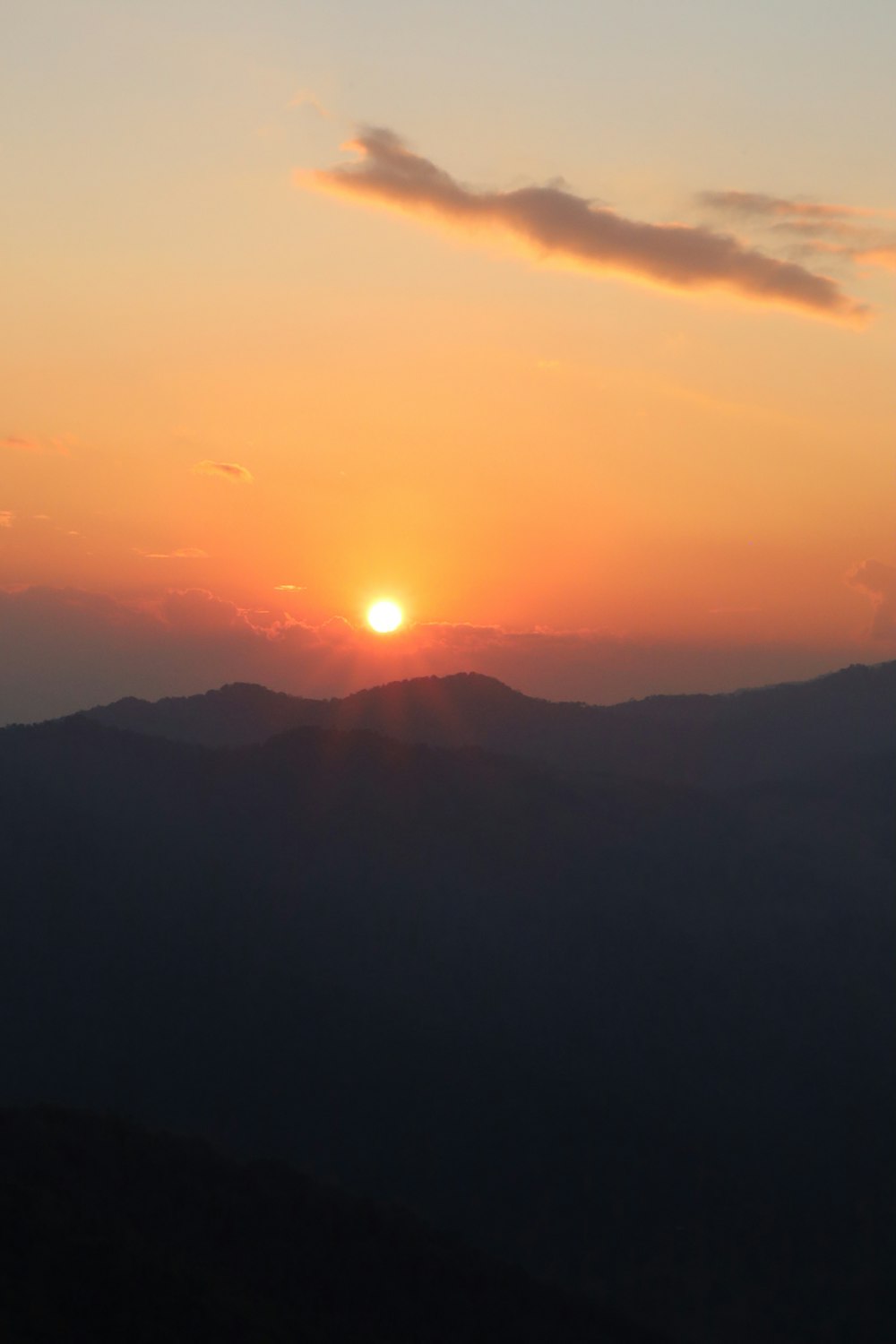 the sun is setting over a mountain range