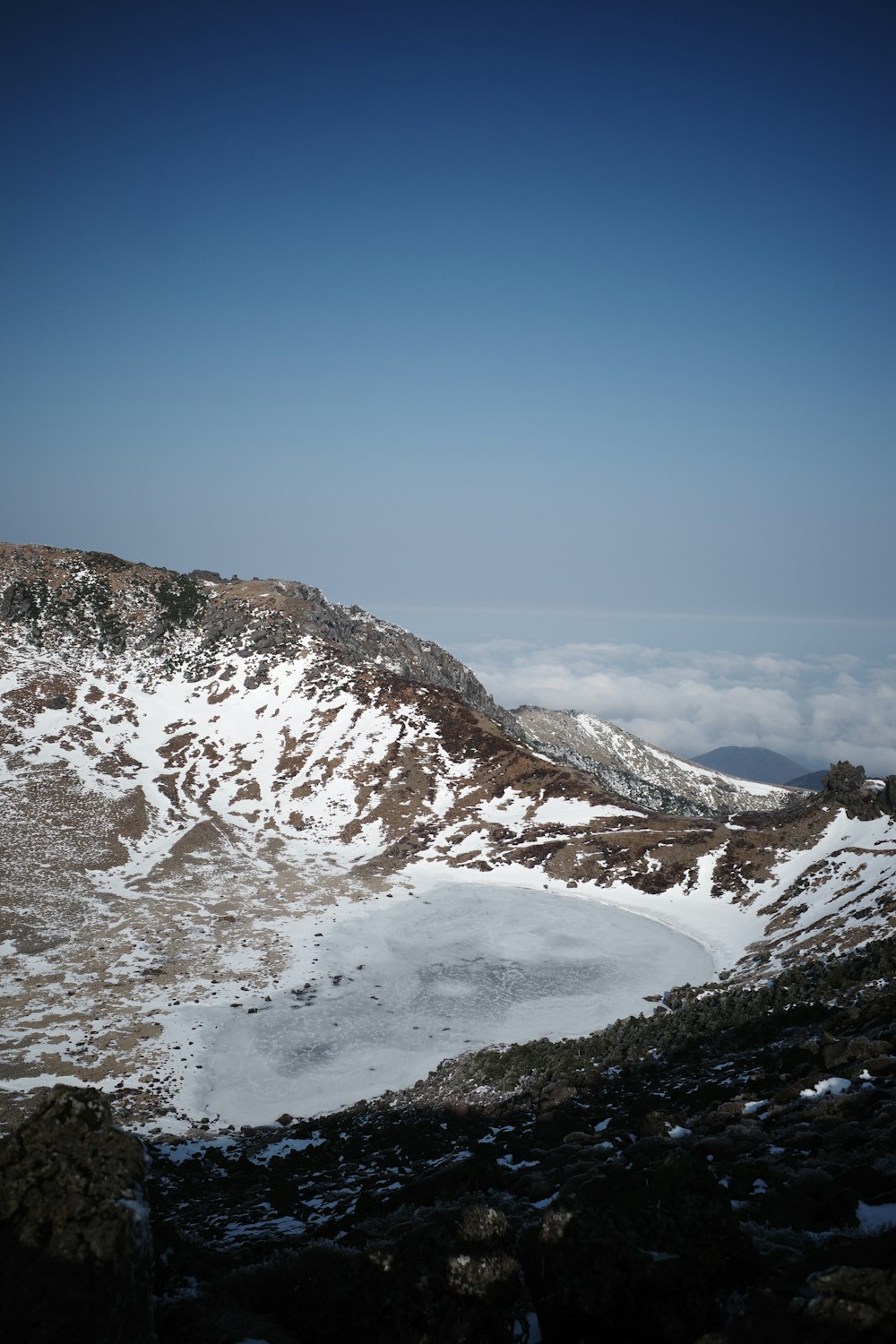 a snow covered mountain with a lake below