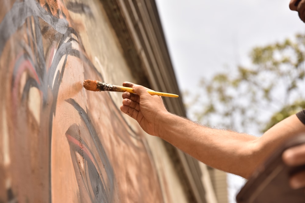 a man is painting a wall with a brush