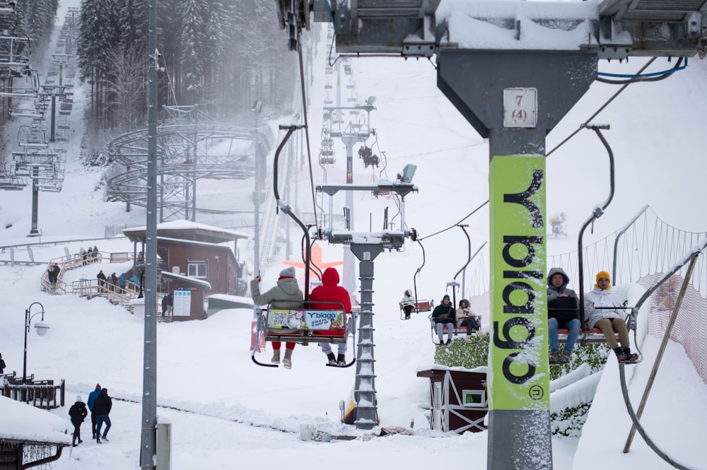 a group of people riding a ski lift in the snow