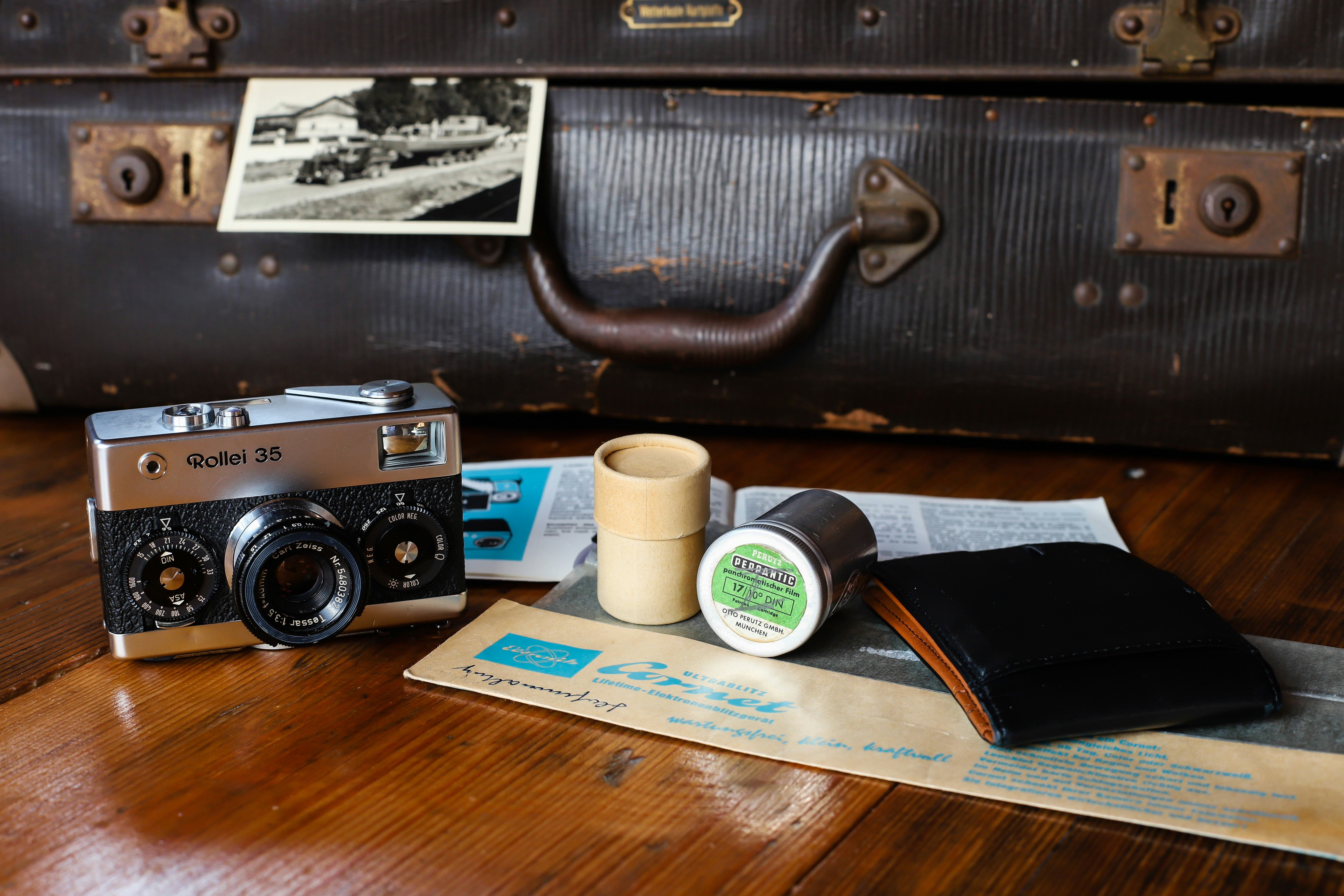 a camera, a cup of coffee, and some other items on a table, 