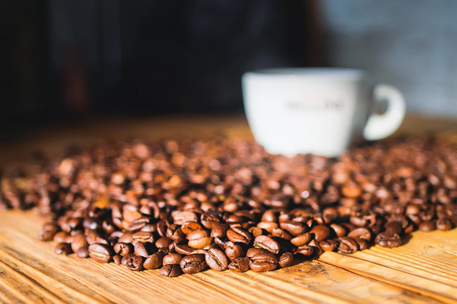 Coffee beans on a wooden table with a cup