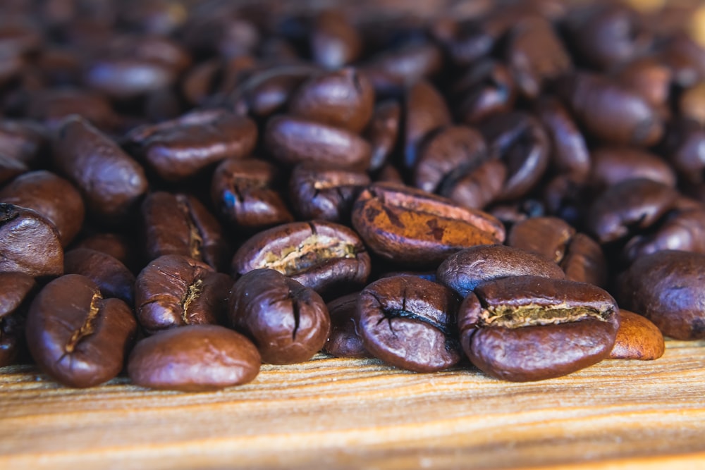 a pile of coffee beans sitting on top of a wooden table