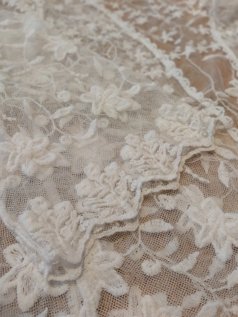 Close-up of lace fabric with embroidered flowers