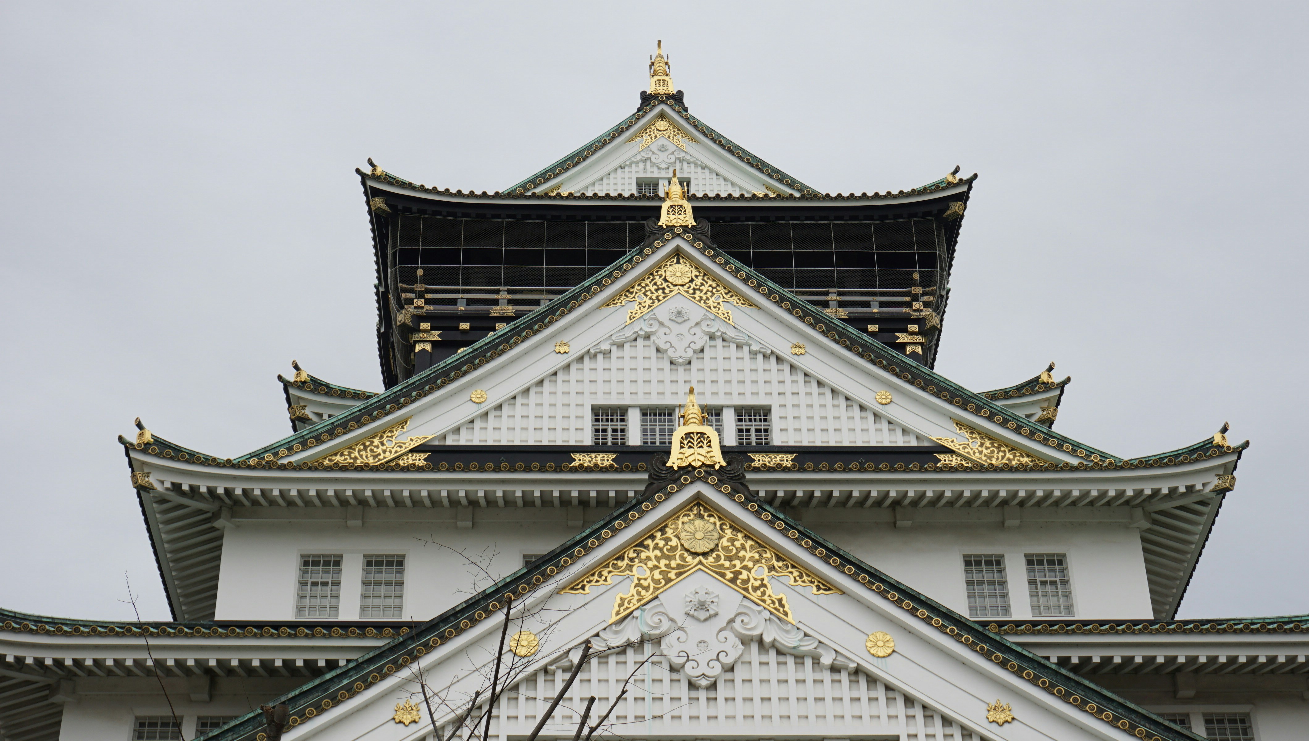 a tall white and gold building with a clock on it's face