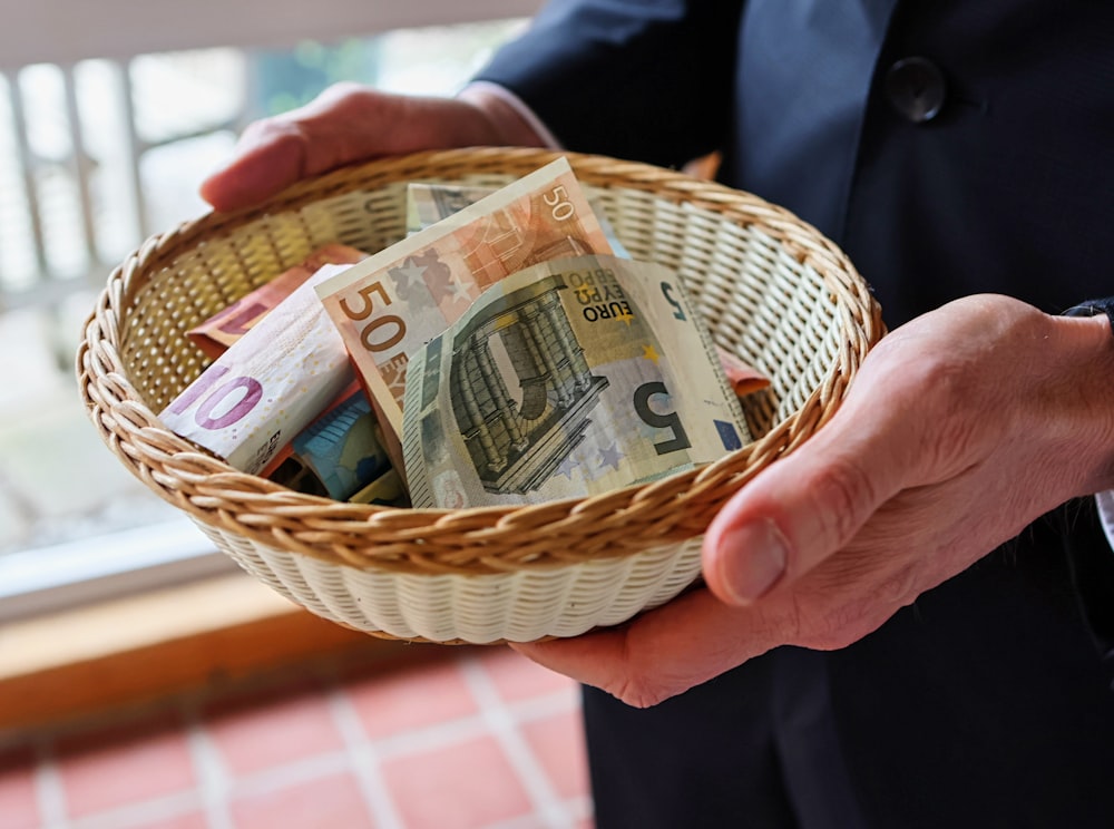 a person holding a basket full of money