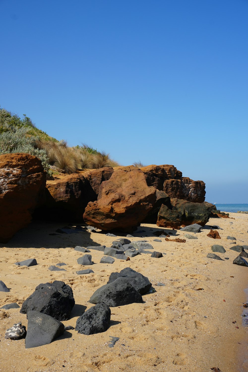 uma praia rochosa com grandes rochas sobre ela