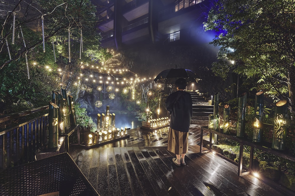 a person standing on a deck with an umbrella