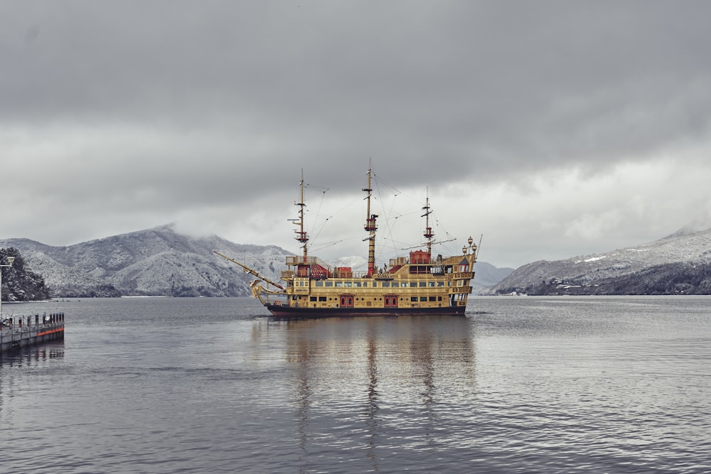 a large yellow boat floating on top of a lake