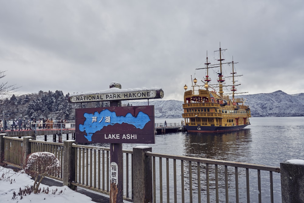 a large boat floating on top of a lake next to a pier