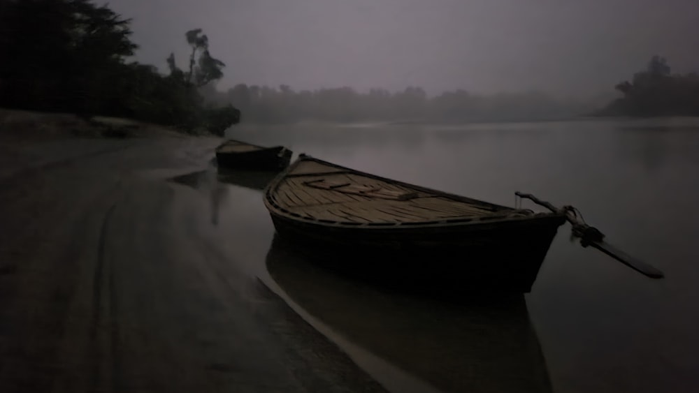 two boats sitting in the water on a foggy day