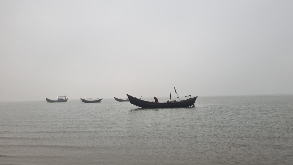 Un grupo de barcos flotando sobre una gran masa de agua