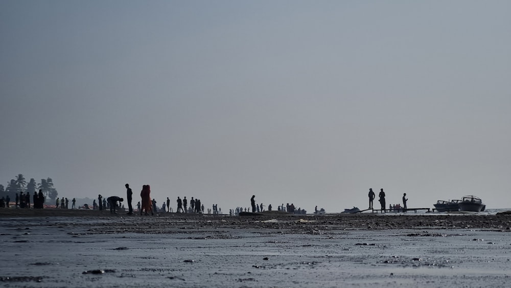 a group of people standing on top of a sandy beach