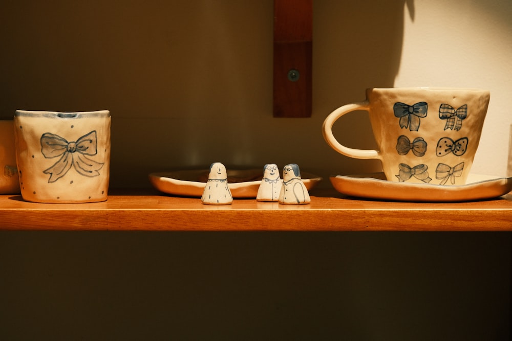a couple of coffee cups sitting on top of a wooden shelf
