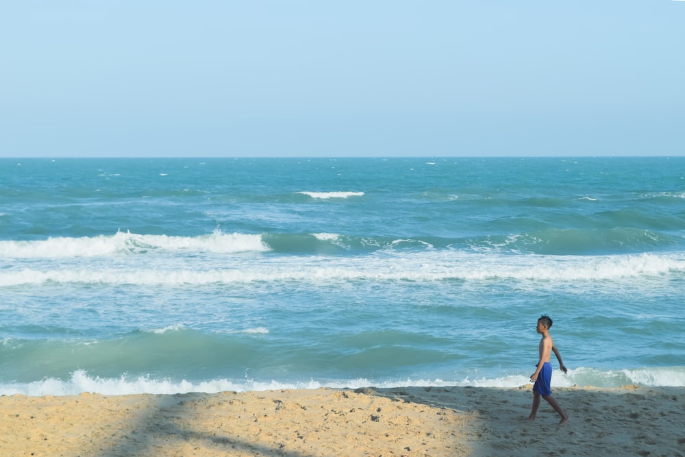 a person walking on a beach next to the ocean