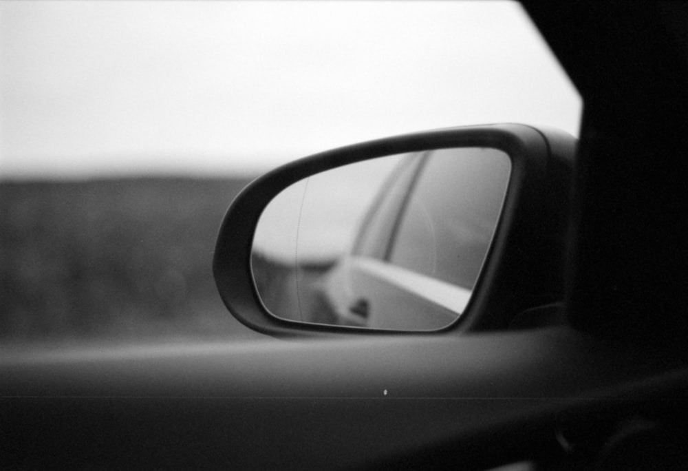 a car's side view mirror is shown in black and white